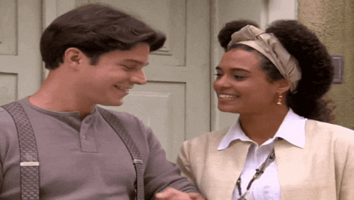 a man and a woman are smiling and holding hands