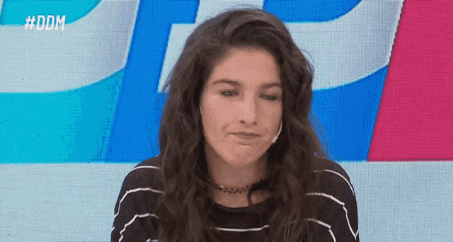 a woman is making a funny face in front of a screen that says #dom on it