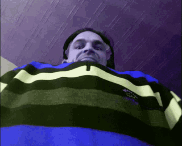 a man is wearing a blue and black striped sweater with the word shark on the front