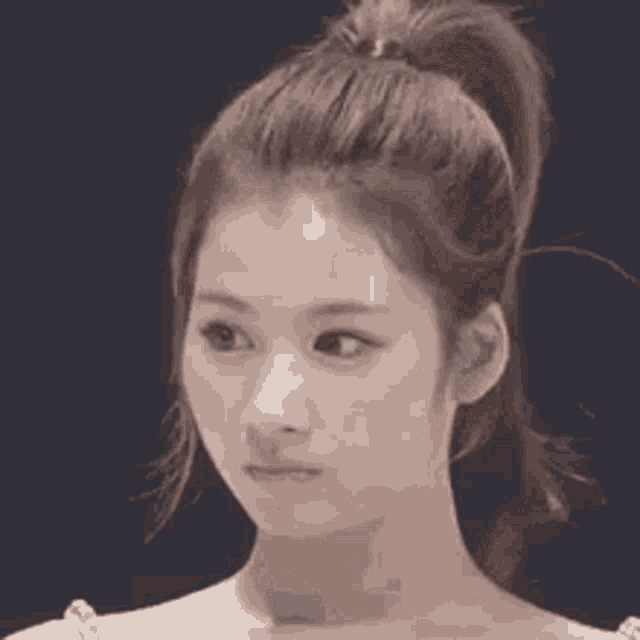 a close up of a woman 's face with a ponytail and a ponytail .
