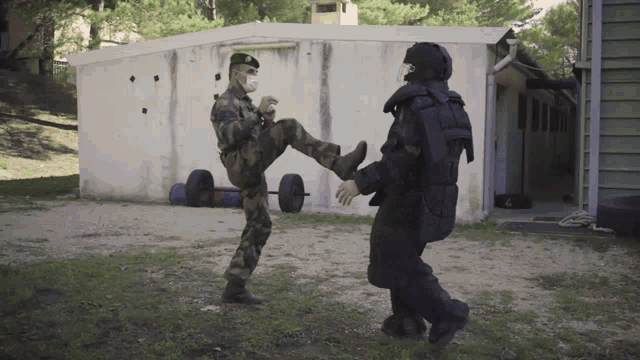 a man wearing a mask kicking another man