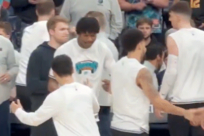 a group of basketball players are standing in a crowd .