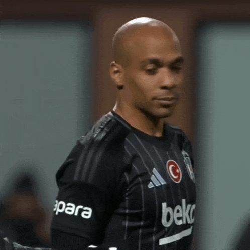 a soccer player wearing a black jersey with beko on the sleeve