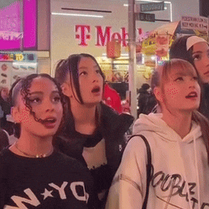 a group of young women standing in front of a t mobile store
