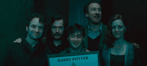 a group of people are posing for a picture with a sign that says harry potter