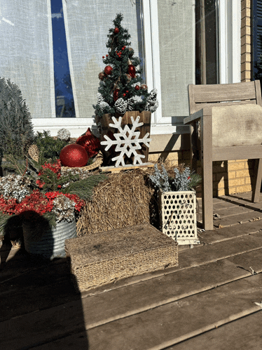 a small christmas tree is sitting on top of a hay bale
