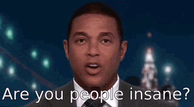 a man in a suit and tie is making a funny face and says are you people insane
