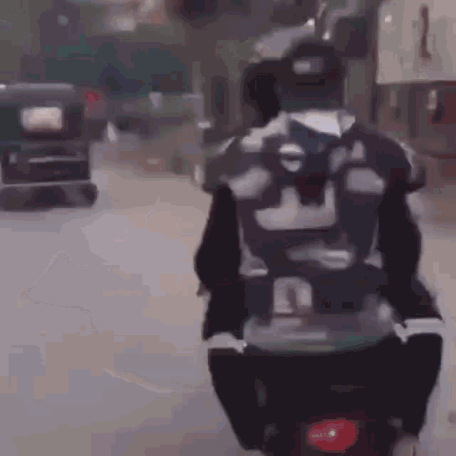 a man riding a motorcycle with a backpack on his back .