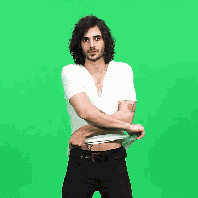 a man with a tattoo of a star on his stomach is taking off his shirt