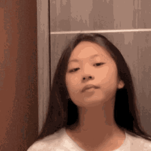 a young girl is looking at herself in a mirror and making a funny face .