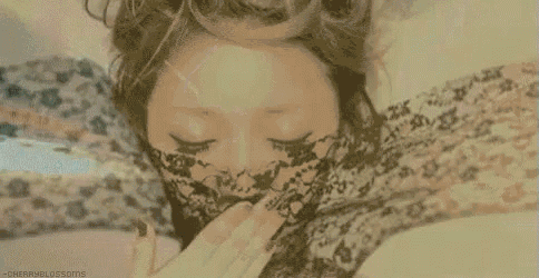 a woman wearing a lace mask is laying in a bathtub with her eyes closed .