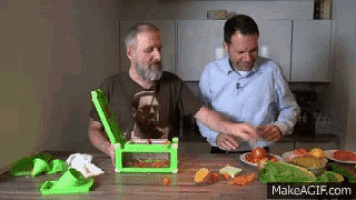 two men are cutting vegetables in a kitchen with makeagif.com in the upper right corner