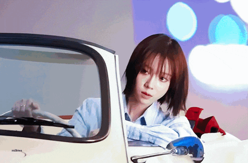 a woman is sitting in a car with the word milken on the side