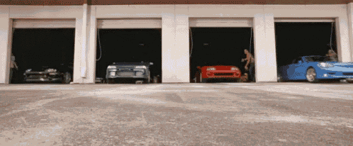 a row of cars are parked in garage doors