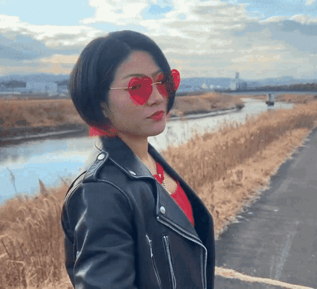 a woman wearing heart shaped sunglasses and a black leather jacket