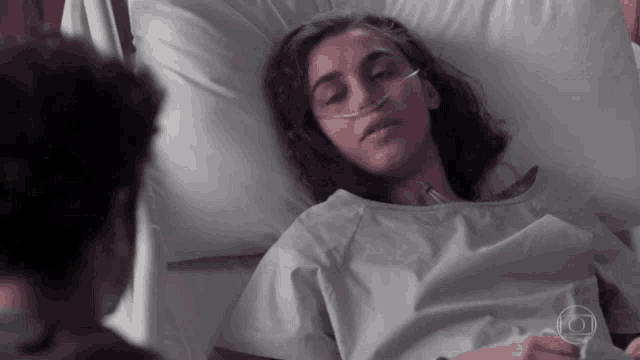 a woman is laying in a hospital bed with an oxygen tube