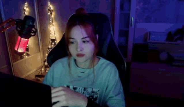 a woman is sitting in a chair using a laptop computer .