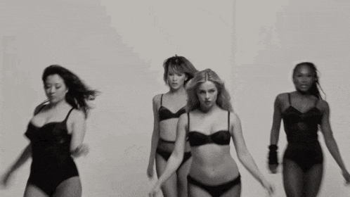 a group of women are dancing in front of a white background