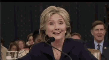 hillary clinton is smiling while giving a speech