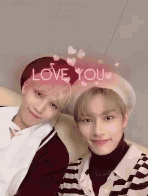 two young men are posing for a picture with hearts and the words love you behind them