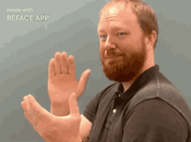 a man with a beard is clapping his hands in front of a screen that says reface app on it