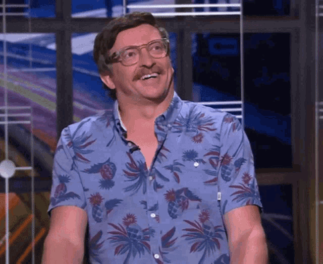 a man in a blue shirt with pineapples on it