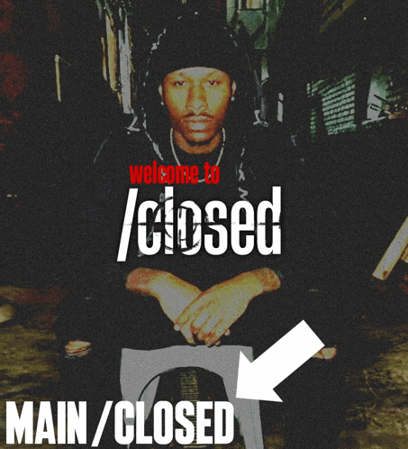 a man sits in front of a sign that says main / closed