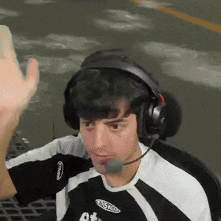 a man wearing headphones and a shirt that says ' altitude ' on it is waving his hand .