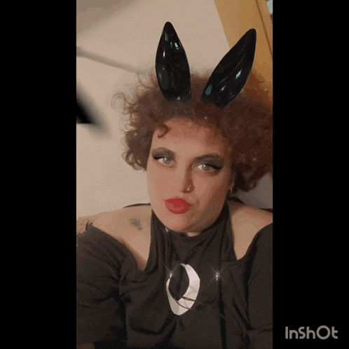a woman wearing black bunny ears and a black shirt with a moon on it