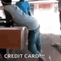 a man is kneeling down in front of a red box with the words `` credit card '' written on it .