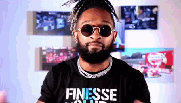 a man with a beard wearing sunglasses and a shirt that says finesse