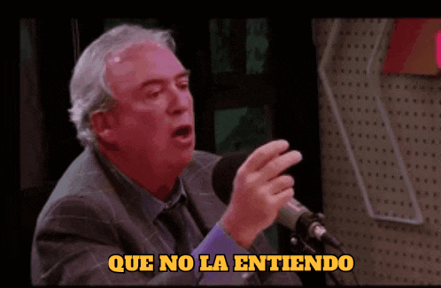 a man speaking into a microphone with the words que no la entiendo written below him