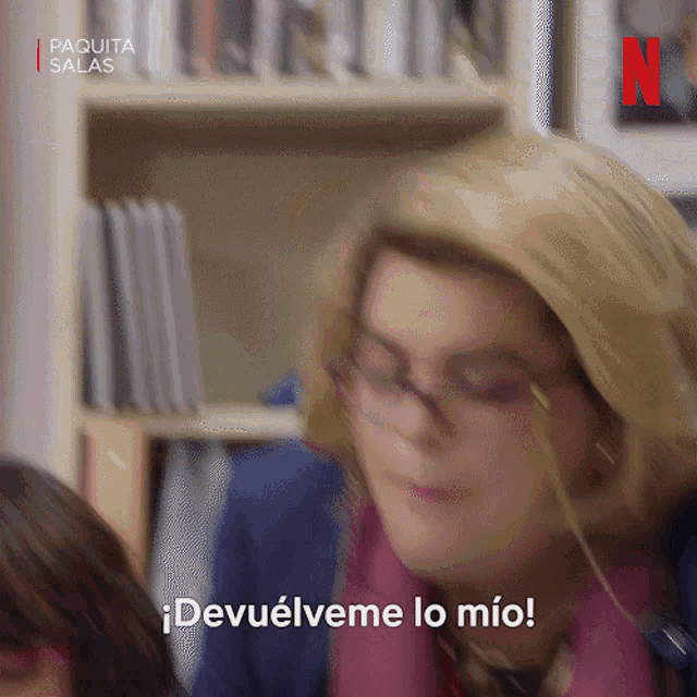 a woman wearing glasses says " devuelve me lo mio "