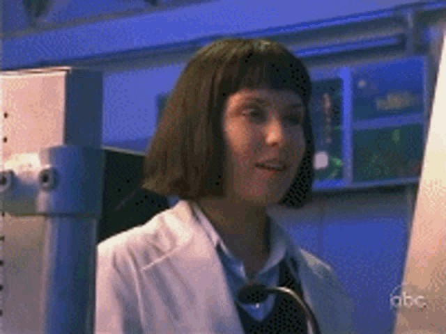 a woman in a lab coat is talking into a microphone