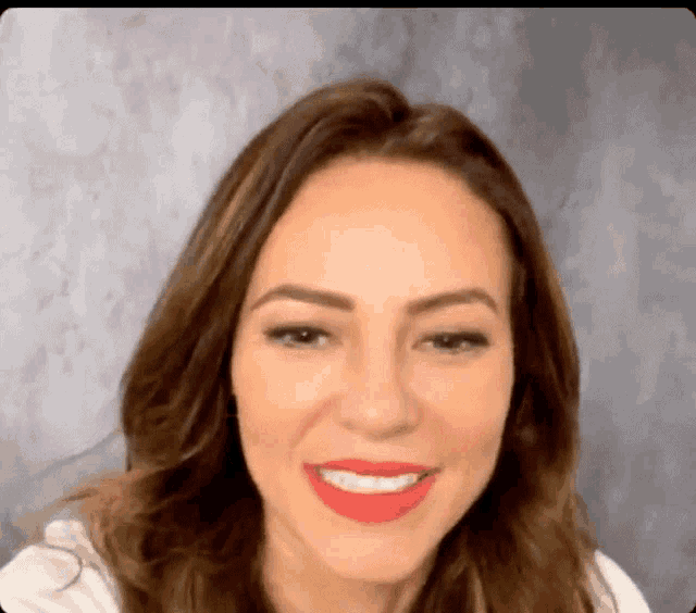 a close up of a woman 's face with red lipstick on her lips .