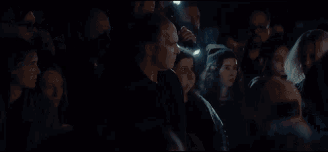 a crowd of people are gathered in a dark room