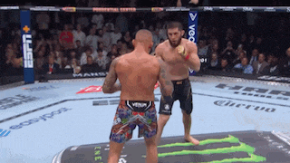 two men are fighting in a boxing ring with a monster energy drink logo on the ground .