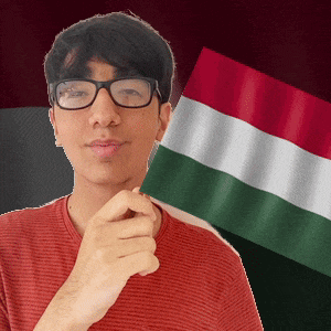 a man wearing glasses holds a green white and red flag in front of his face