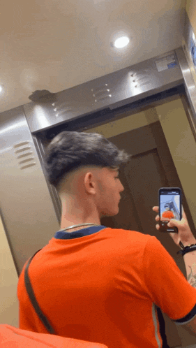 a man taking a picture of himself in an elevator with his phone