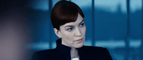 a close up of a woman 's face with a blue sky in the background