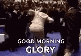 a man is dancing in front of a crowd with the words `` good morning glory '' written above him .