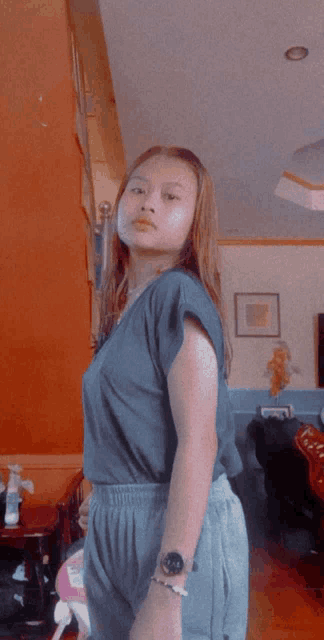 a woman wearing a watch and a bracelet is standing in a living room