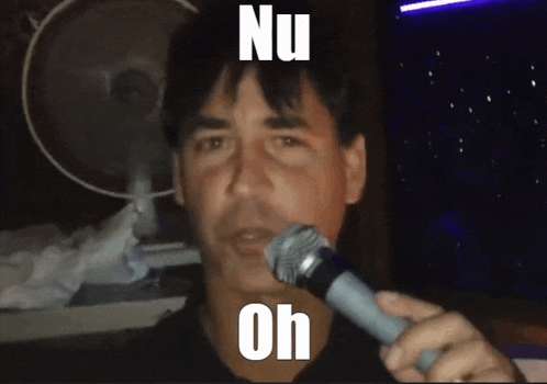 a man singing into a microphone with the words nu oh written on his face