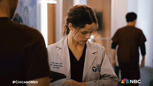 a woman in a lab coat is standing in a hallway with #chicagomed written on the bottom
