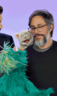 a man with a beard is holding a stuffed animal