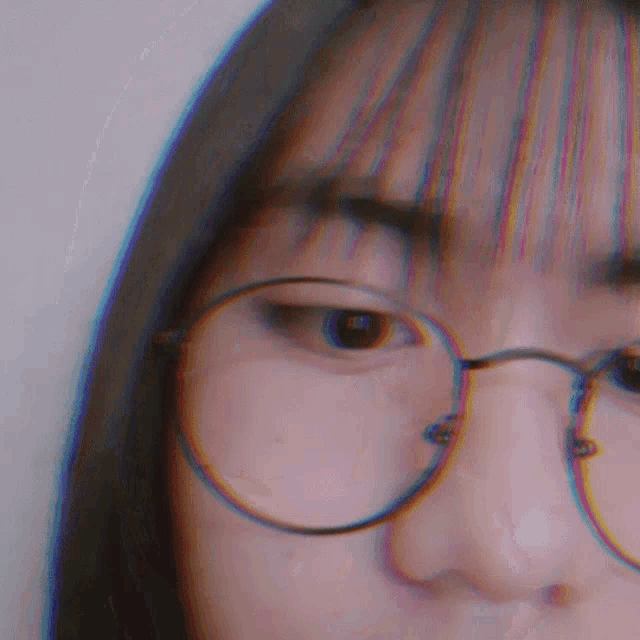 a close up of a woman 's face with glasses
