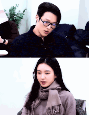a man wearing glasses and a woman wearing a scarf looking at each other