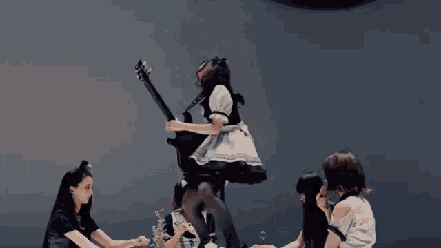 a woman in a maid costume is playing a guitar