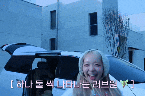 a woman is smiling in front of a car with korean writing