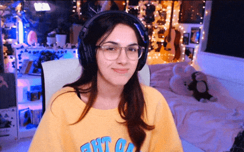 a woman wearing headphones and a yellow shirt that says " out " on it